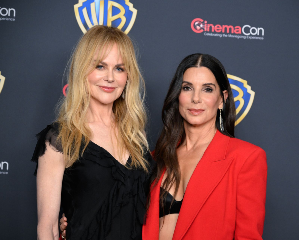 Nicole Kidman and Sandra Bullock appear at an event in wavy hairstyles.
